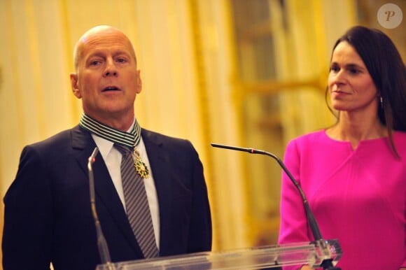 Bruce Willis réagit à l'honneur qui lui est fait au côté de la ministre Aurélie Filippetti à Paris, le 11 février 2013.