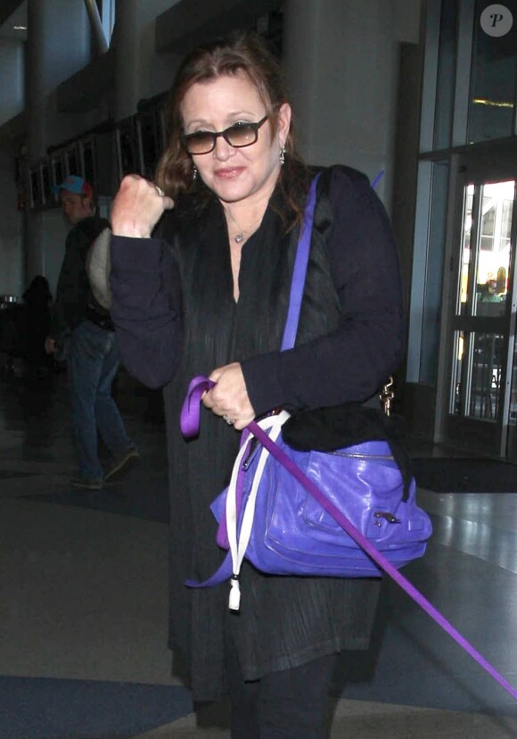 Carrie Fisher prend l'avion avec son chien à Los Angeles le 21 août 2012