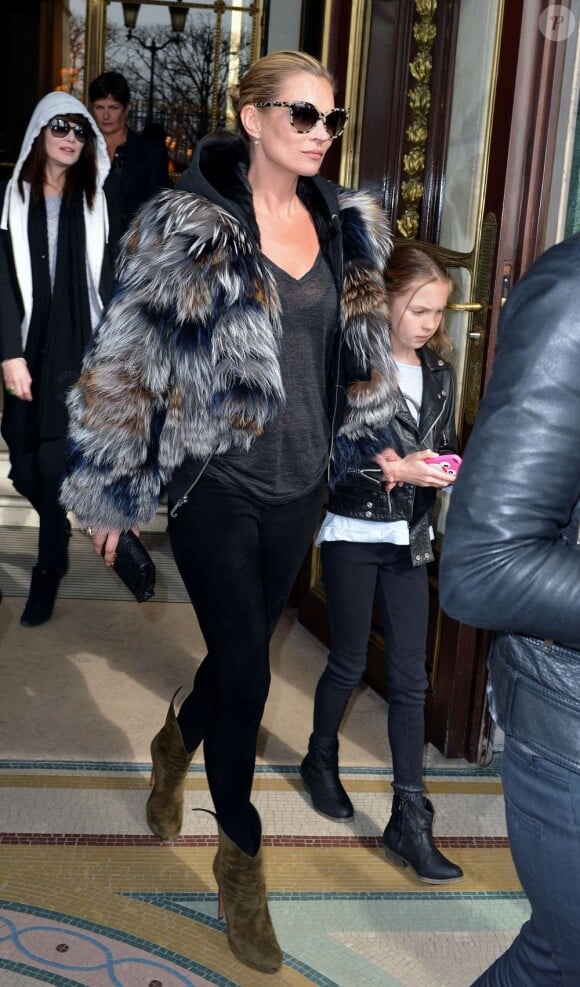 Kate Moss, ultrachic et décontractée avec sa fille Lila Grace à la sortie de l'hôtel Le Meurice, porte une veste en fourrure sur un swear à capuche et un T-shirt légèrement transparent, un legging et des bottines Azzedine Alaïa. Paris, le 6 mars 2013.