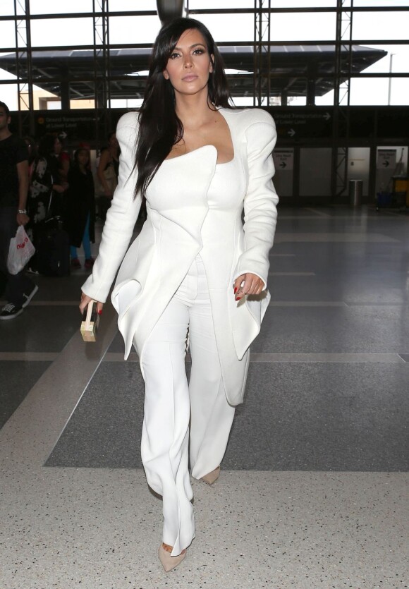 Kim Kardashian, enceinte, arrive à l'aéroport de Los Angeles pour rejoindre Paris. Elle porte une veste Thierry Mugler de la collection automne-hiver 2012, un pantalon évasé Chloé et des souliers Jimmy Choo. Le 2 mars 2013.