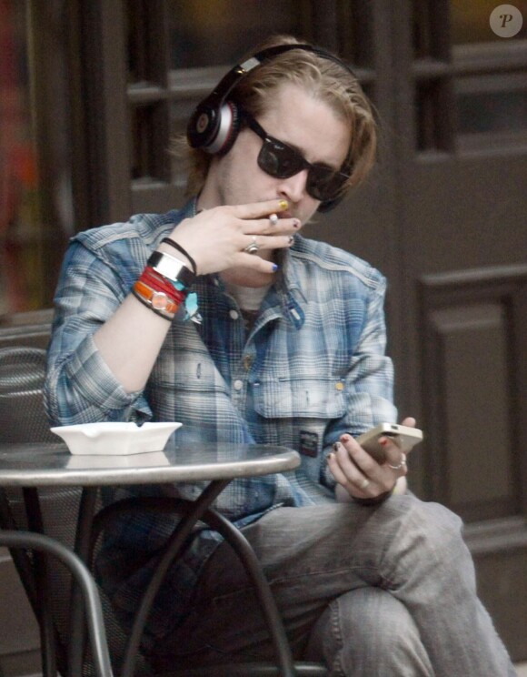 Macaulay Culkin seul à la terrasse d'un café à Londres, le 17 avril 2013.