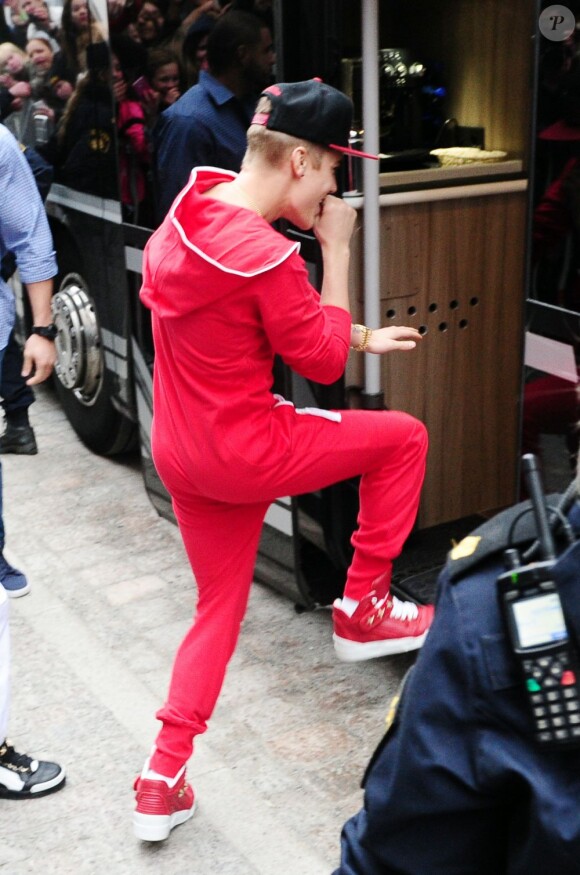 Justin Bieber, très enjoué, sort de son hôtel en dansant avec un ami pour se rendre à son concert à Stockholm, le 24 avril 2013.