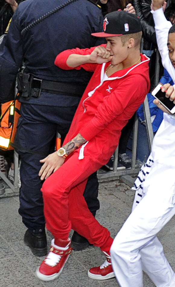 Justin Bieber, étrangement enjoué, sort de son hôtel en dansant avec un ami pour se rendre à son concert à Stockholm, le 24 avril 2013.