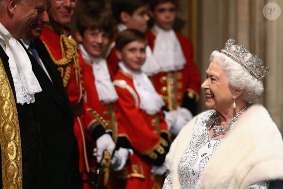 La reine Elizabeth II, ici à son arrivée, portant le diadème George IV, présidait le 8 mai 2013 au palais de Westminster sa 60e ouverture cérémonielle du Parlement, en la présence habituelle de son époux le duc d'Edimbourg, et exceptionnelle de son fils le prince Charles, pour la première fois en 17 ans, et de Camilla Parker Bowles.