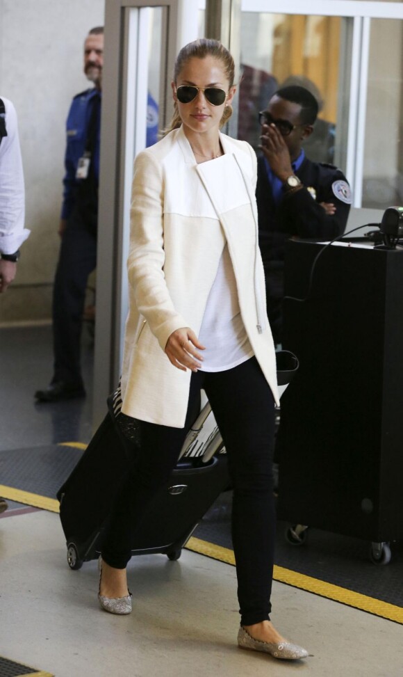 Minka Kelly à l'aéroport de Los Angeles, habillée de lunettes Ray-Ban, d'un manteau Maje porté sur un t-shirt blanc et un pantalon noir, et des ballerines Chloé. Le 14 mai 2013.