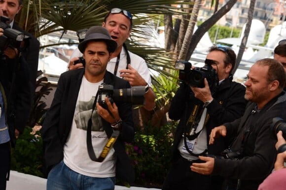 Jamel Debbouze chipe un appareil photo au photocall de Né Quelque Part au Palais des Festivals, le 21 mai 2013.