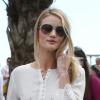 Rosie Huntington-Whiteley, en promenade sur la Croisette à Cannes, porte des lunettes Burberry, un chemisier Vanessa Bruno, une jupe Chloé et des souliers Manolo Blahnik. Le 22 mai 2013.