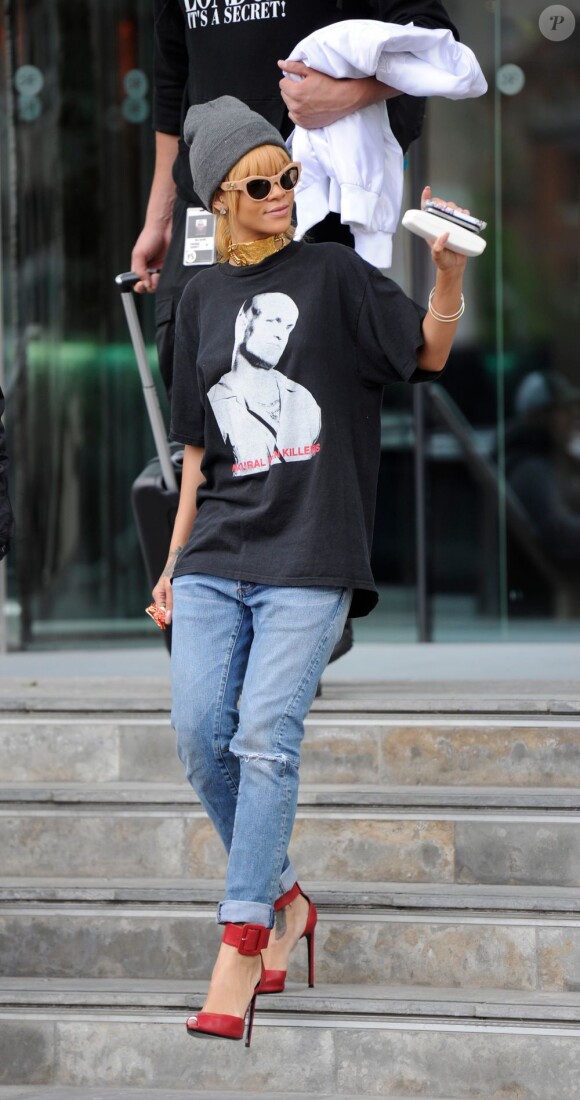 Rihanna, stylée avec des lunettes Versace, un collier vintage Christian Lacroix et des chaussures Saint Laurent, quitte l'hôtel Lowry où elle a résidé pendant ses quelques jours à Manchester. Le 13 juin 2013.