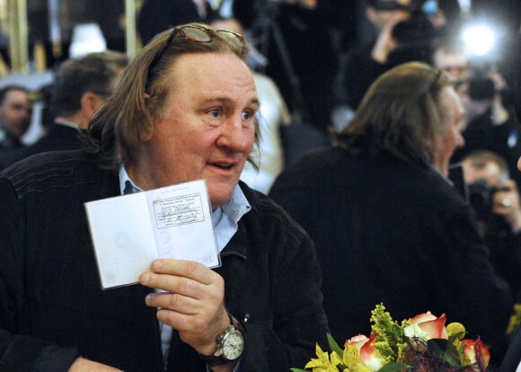 Gérard Depardieu montre fièrement son passeport de citoyen Russe lors de sa visite a Saransk, le 23 février 2013