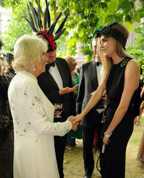 Mario Testino présentant Cara Delevingne à la duchesse de Cornouailles lors de la réception organisée à Clarence House le 9 juillet 2013 par le prince Charles et Camilla Parker Bowles en faveur de The Elephant Family.