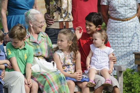 La princesse Athena sur les genoux de son cousin Nikolai. La famille royale de Danemark en séance photo le 26 juillet 2013 pour les médias dans le parc du château de Grasten, résidence d'été royale. Autour de la reine Margrethe II et du prince Henrik, le prince Frederik et la princesse Mary, et le prince Joachim et la princesse Marie, avec tous leurs enfants, ainsi que la princesse Benedikte, le prince Gustav et la princesse Alexandra de Sayn-Wittgenstein-Berleburg, et la reine Anne-Marie de Grèce étaient rassemblés.