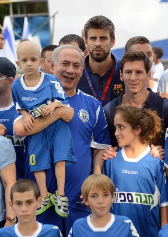 Le Premier ministre israélien Benjamin Netanyahu avec les stars du FC Barcelone Gerard Piqué et Lionel Messi avec des enfants atteints d'un cancer à Kfar Maccabiah, le 4 août 2013.