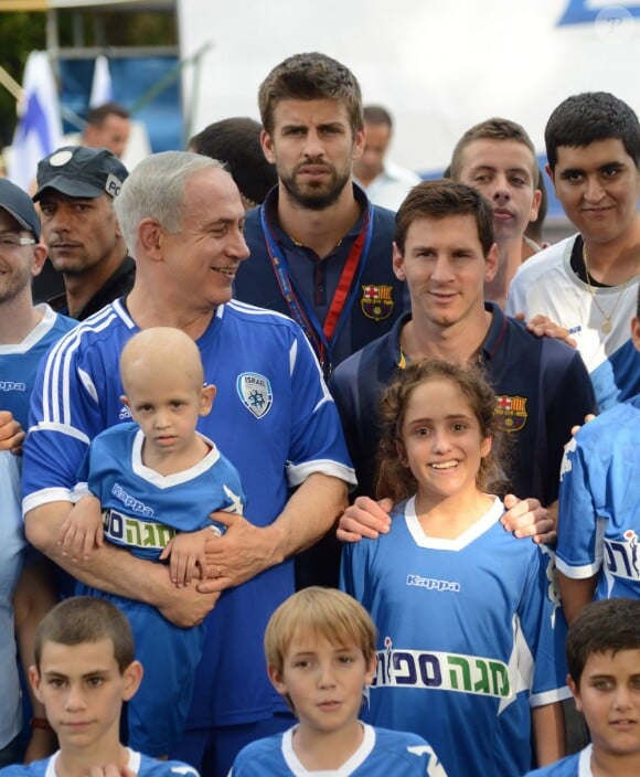 Le Premier ministre israélien Benjamin Netanyahu avec les stars du Barça Gerard Piqué et Lionel Messi, et des enfants atteints d'un cancer à Kfar Maccabiah, le 4 août 2013.