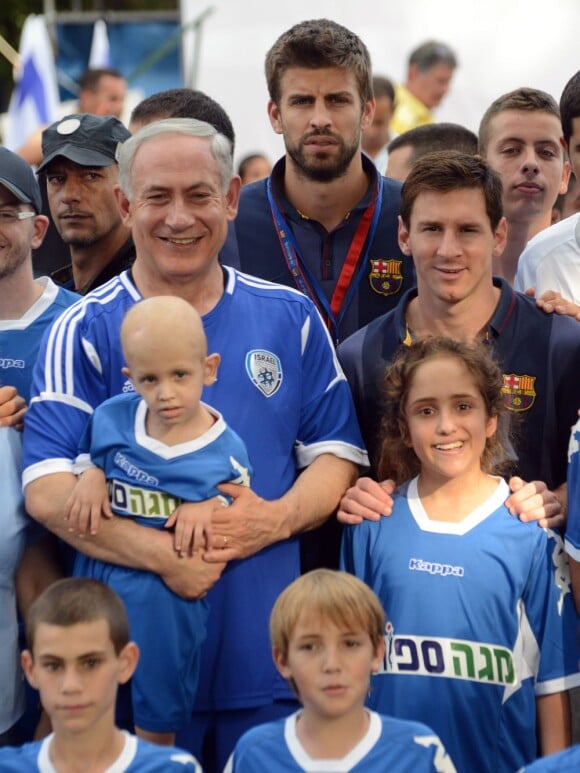 Le Premier ministre israélien Benjamin Netanyahu avec les stars du Barça Gerard Piqué et Lionel Messi avec des enfants atteints d'un cancer à Kfar Maccabiah, le 4 août 2013.