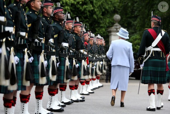 Elizabeth II lors de la revue des troupes des Royal Scots Borderers (1 Scots) à Balmoral, en compagnie du Major Jules Kilpatrick, le 8 août 2013.