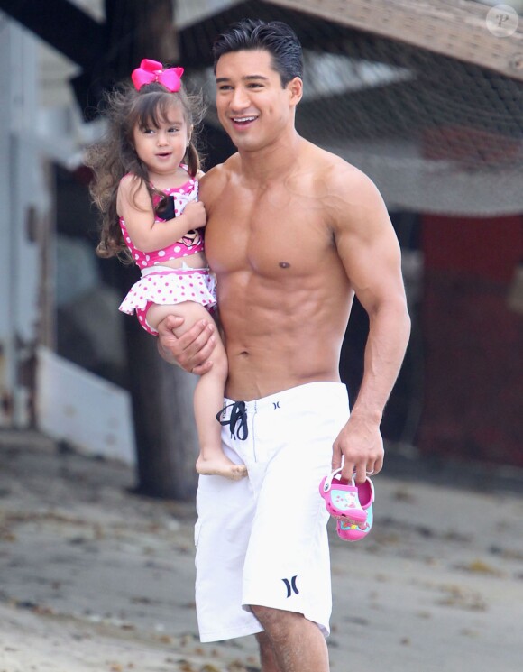 Exclusif - Mario Lopez se promène sur la plage avec sa fille Gia avant d'aller faire du surf à Malibu, le 28 juillet 2013.
