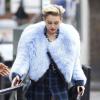 Exclusif - Miley Cyrus, habillée d'un manteau en fourrure, d'une chemise Saint Laurent et de bottes Christian Louboutin, quitte un studio photo à Londres, le 11 septembre 2013.