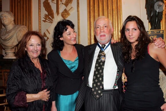 Michel Serrault posant avec sa femme Nita (Juanita), sa fille Nathalie et sa petite-fille Gwendoline lorsqu'il reçoit la médaille de Commandeur dans l'Ordre national du mérite au ministère de la Culture le 1er octobre 2004 à Paris