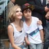 Cara Delevingne, star adorable avec un jeune fan devant l'hôtel Fasano à Rio de Janeiro. Le 3 octobre 2013.