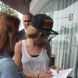 Cara Delevingne prend des photos avec ses jeunes admiratrices devant l'hôtel Fasano à Rio de Janeiro. Le 3 octobre 2013.