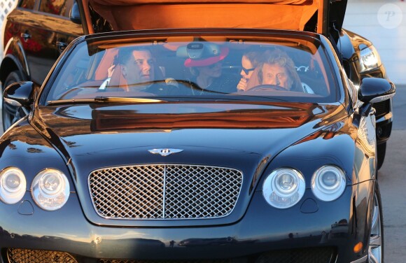 Johnny Hallyday en voiture avec Thierry Chassagne, le président de Warner Music France, la maison de disques du chanteur, et sa femme Laeticia Hallyday à l’arrière, le 9 novembre 2013.