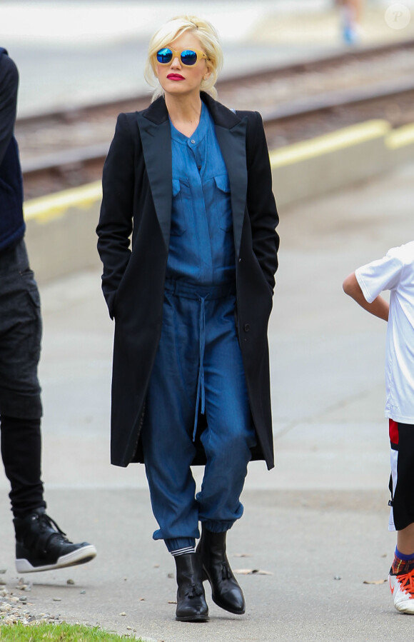 Gwen Stefani, enceinte, porte avec son long manteau noir une combinaison Hatch et des bottines noires à glands All Saints (modèle Kiss). Los Angeles, le 23 novembre 2013.