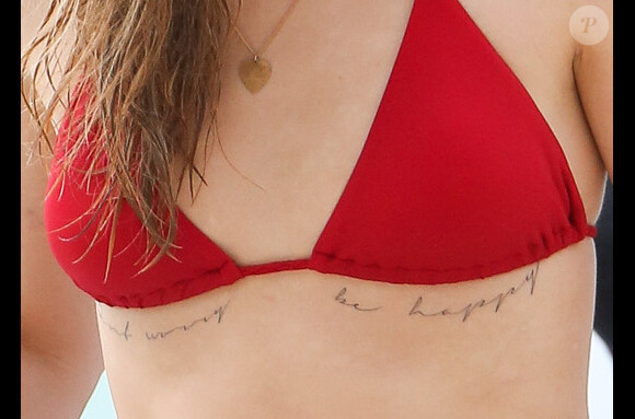 Cara Delevingne, exhibe son nouveau tatouage "Don't worry be happy", en vacances à la Barbade, le 26 décembre 2013.