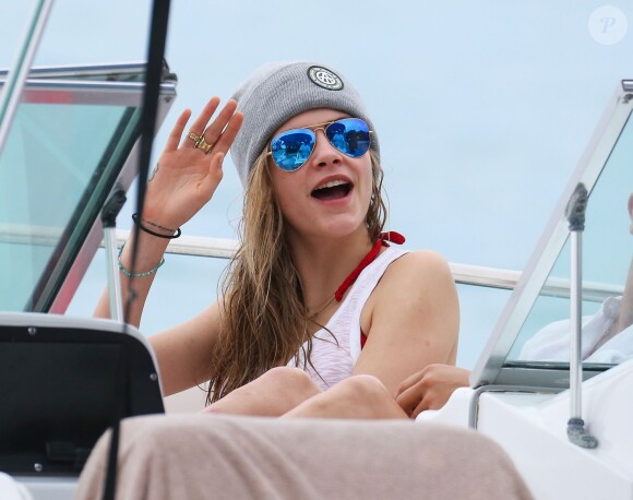 Cara Delevingne fait un tour en bateau lors de ses vacances à la Barbade, le 26 décembre 2013. Cara exhibe son nouveau tatouage "Don't worry be happy".