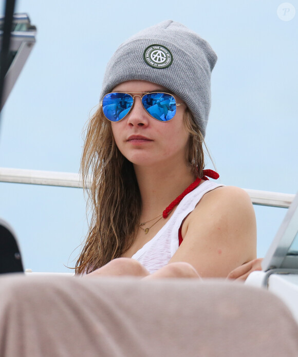 Cara Delevingne fait un tour en bateau lors de ses vacances à la Barbade, le 26 décembre 2013. Cara exhibe son nouveau tatouage "Don't worry be happy".