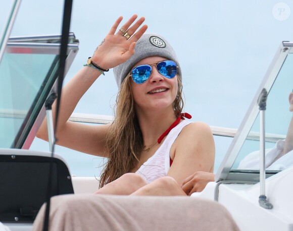 Cara Delevingne fait un tour en bateau lors de ses vacances à la Barbade, le 26 décembre 2013. Cara exhibe son nouveau tatouage "Don't worry be happy".