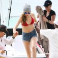 Cara Delevingne fait un tour en bateau lors de ses vacances à la Barbade, le 26 décembre 2013. Cara exhibe son nouveau tatouage "Don't worry be happy".