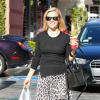 Reese Witherspoon en pleine mission courses à West Hollywood, porte un sweater noir, une craquante jupe léopard, un sac Reed Krakoff (modèle Bionic Atlantique) et des bottines Saint Laurent. Le 23 décembre 2013.