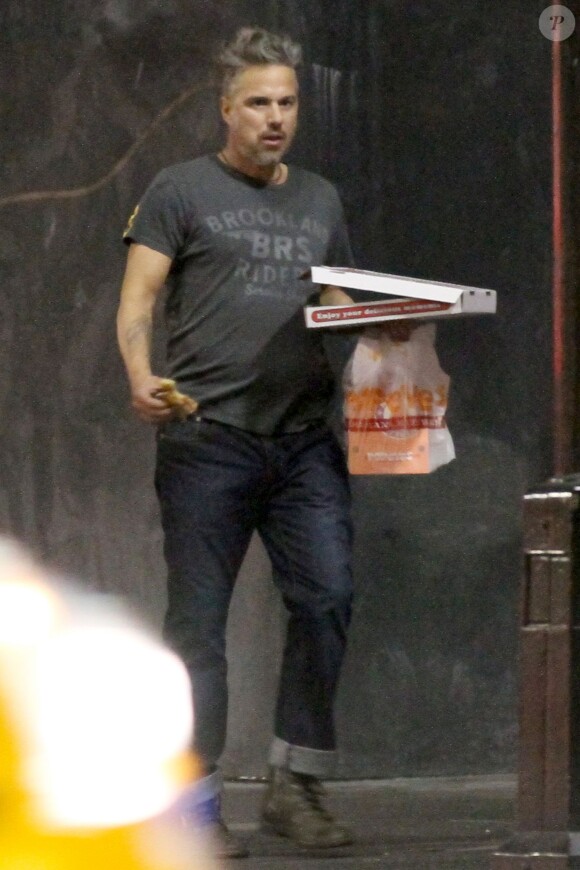 Jason Trawick mange une pizza et du poulet rôti après une soirée à Los Angeles, le 17 janvier 2014.