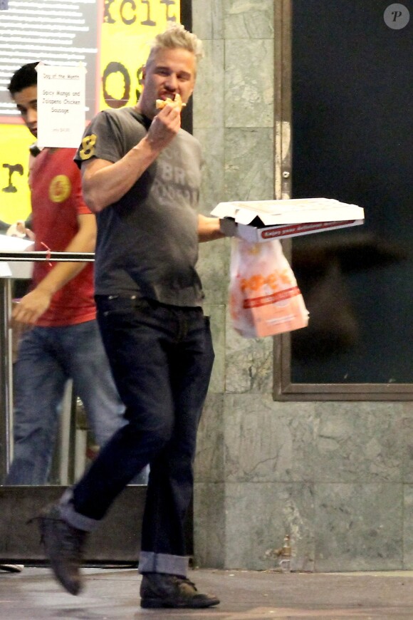 Jason Trawick mange une pizza dans les rues de Los Angeles, le 17 janvier 2014.