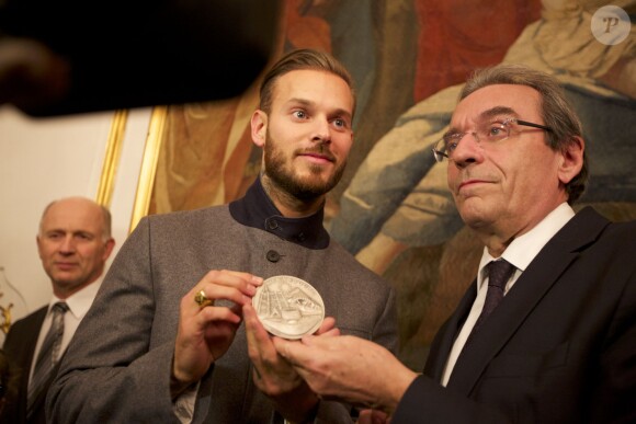 Le chanteur M. Pokora a reçu des mains du maire de Strasbourg Roland Ries la médaille d'honneur de la ville, lors d'une cérémonie organisée en présence de fans à l'hôtel de ville de Strasbourg, le 12 février 2014.