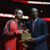 Joakim Noah reçoit le trophée du meilleur défernseur de la NBA des mains de Dikembe Mutombo, au United Center de Chicago le 22 avril 2014 avant le match 2 face aux Wizards de Washington