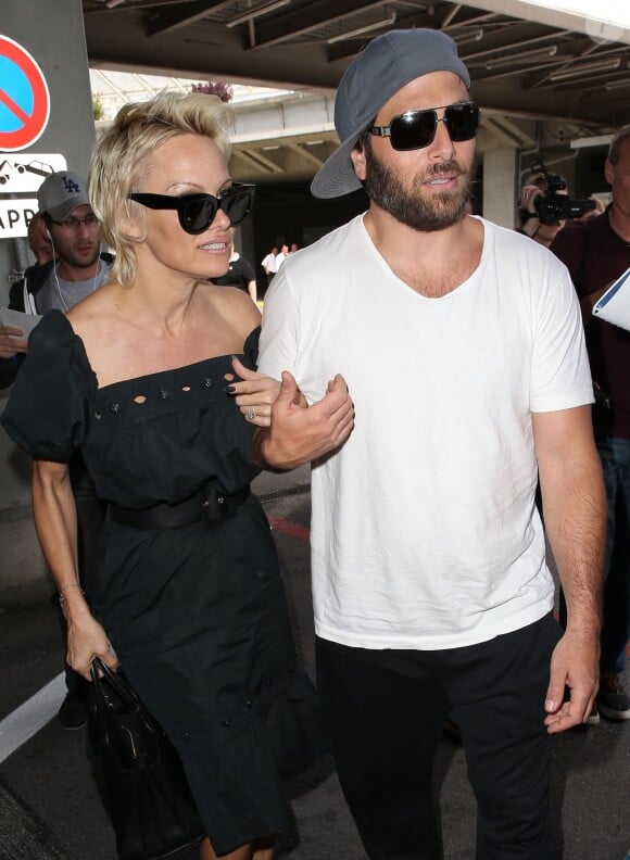 Pamela Anderson, attendue par de nombreux fans à qui elle a signé des autographes, arrive avec son mari Rick Salomon à l'aéroport de Nice pour le festival de Cannes, le 13 mai 2014. L'actrice et son mari se sont ensuite rendus à l'hôtel Eden-Roc au Cap d'Antibes.