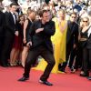 Quentin Tarantino danse pour les 20 ans de Pulp Fiction à la montée des marches du film "Sils Maria" lors du 67e Festival du film de Cannes le 23 mai 2014.