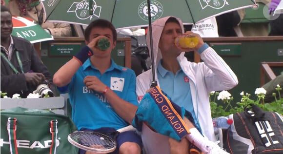 Novak Djokovic et son ramasseur partage un verre lors du second jour des internationaux de France, à Roland-Garros, le 26 mai 2014