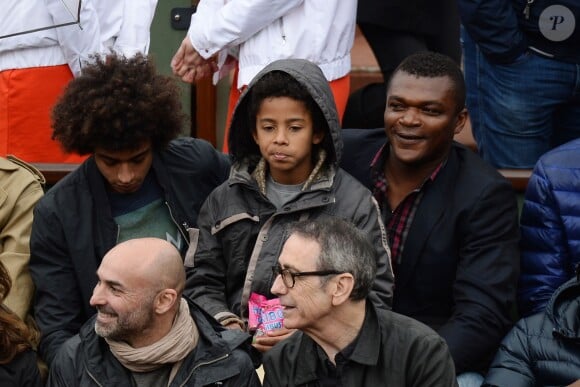 Marcel Desailly et ses enfants pendant le match entre Jo-Wilfried Tsonga et Jürgen Melzer à Roland-Garros à Paris, le 28 mai 2014. 