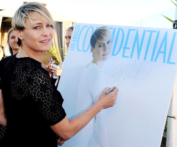 Robin Wright signe sur la couverture du magazine Los Angeles Confidential à Los Angeles, le 4 juin 2014.