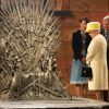 Elizabeth II et le prince Philip devant le fameux Trône de Fer de la série "Game of Thrones". Visite dans les décors de la série aux Titanic Studios à Belfast, le 24 juin 2014.