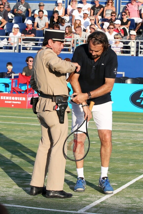 Henri Leconte et le gendarme de Saint-Tropez lors de la 4ème édition du Classic Tennis Tour à Saint-Tropez, le 12 juillet 2014.