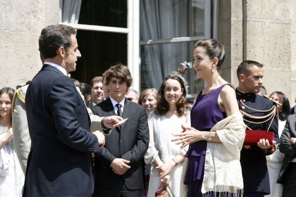 Nicolas Sarkozy décore Ingrid Betancourt dans les jardins de l'Elysée, le 14 juillet 2008. Lozenzo et Mélanie, les enfants de l'ex-otage, sont au premier rang.