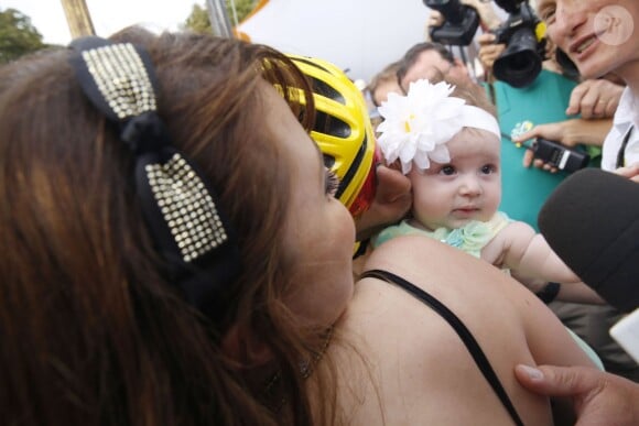 Dans les bras de sa maman Rachele, la petite Emma, 5 mois, félicite son papa Vincenzo Nibali pour sa victoire dans le Tour de France, le 27 juillet 2014 lors de l'arrivée sur les Champs-Elysées.