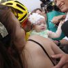 Dans les bras de sa maman Rachele, la petite Emma, 5 mois, félicite son papa Vincenzo Nibali pour sa victoire dans le Tour de France, le 27 juillet 2014 lors de l'arrivée sur les Champs-Elysées.