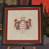 Photo de l'enluminure des armes de la principauté de Monaco offerte au prince Albert II lors de sa venue au Puy du Fou le 25 juillet 2014, notamment pour une cérémonie caritative en faveur de l'association du Père Pedro, Akamasoa.