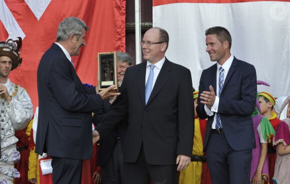 Philippe de Villiers, le prince Albert II de Monaco, Nicolas de Villiers au parc du Puy du Fou le 25 juillet 2014 lors d'une cérémonie de remise d'un chèque de 50 000 euros au père Pedro pour son association Akamasoa.