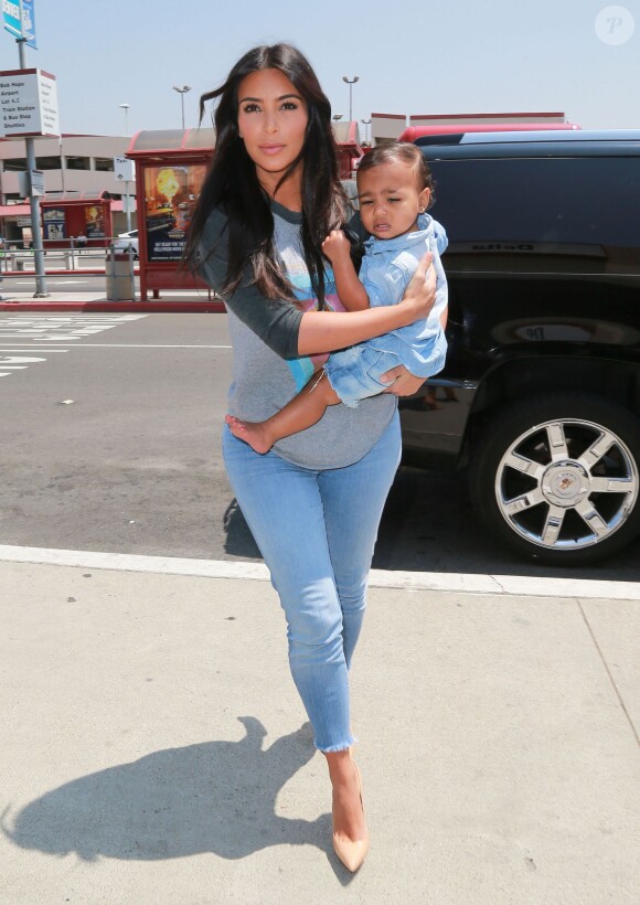 Pour échapper aux paparazzi de l'aéroport LAX, Kim Kardashian et sa fille North se sont rendues à celui de Burbank. Le 7 août 2014.