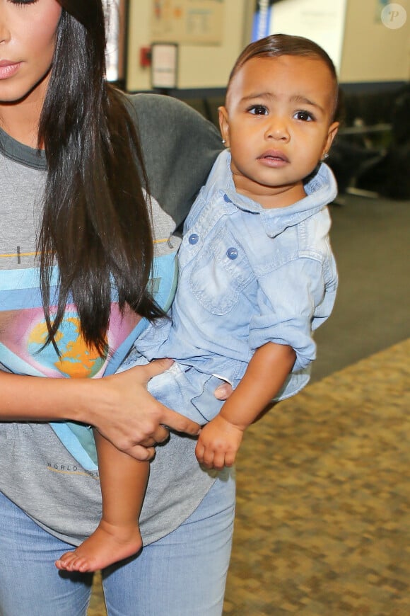 North West, craquante dans les bras de sa maman Kim Kardashian à l'aéroport de Burbank. Le 7 août 2014.
